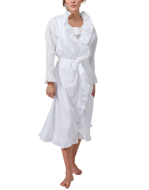 A woman wears the Haute Home Ruffle Robe in 100% white cotton sateen, featuring long sleeves, ruffled trim, a waist tie belt, and a matching nightgown underneath.