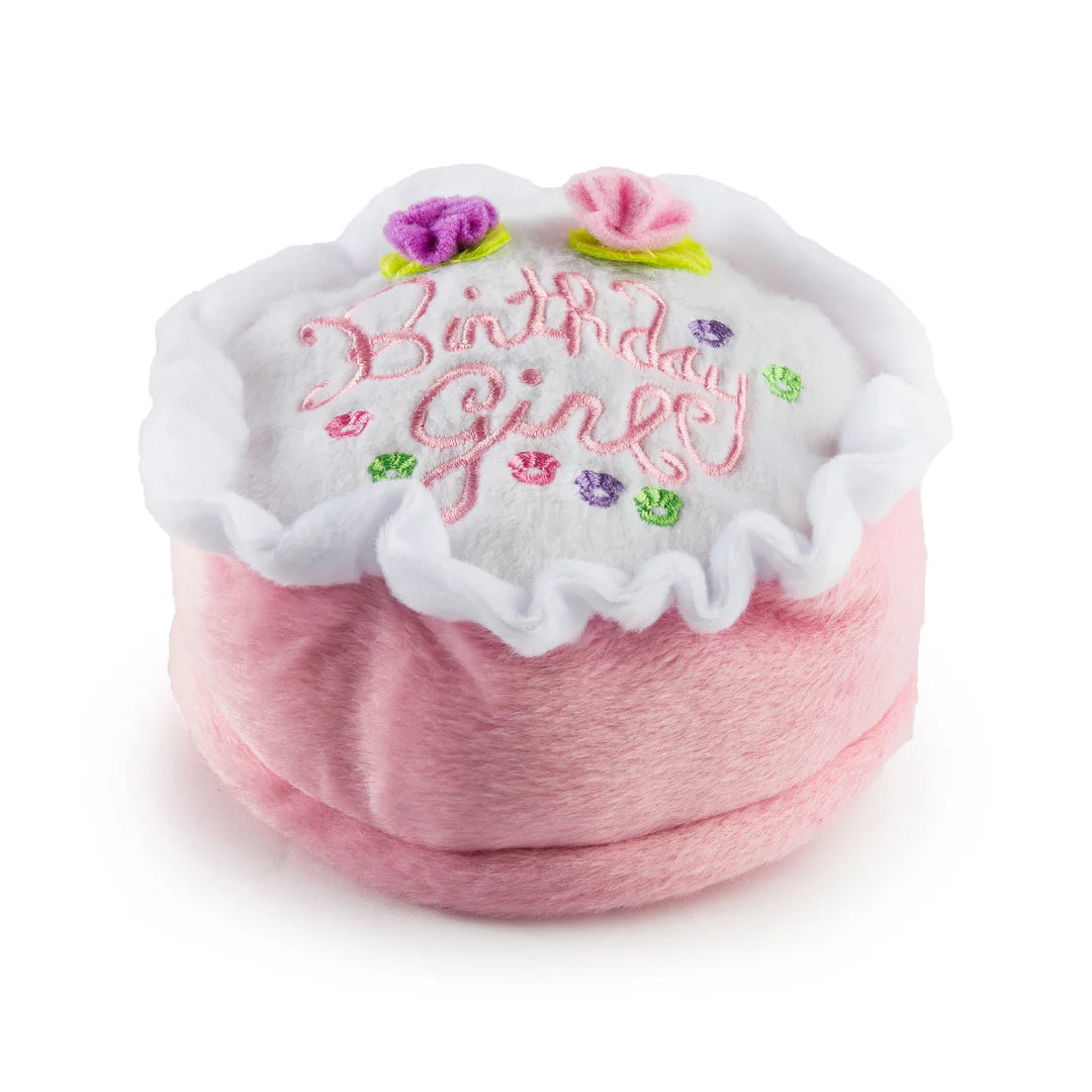 The Haute Diggity Dog Birthday Girl Toy is a round, plush dog toy with pink sides, a white top, "Birthday Girl" embroidery, and fabric flowers—perfect for your pup’s birthday celebration.