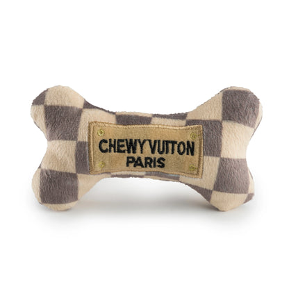 The Haute Diggity Dog Checker Chewy Vuiton Bone is a plush, squeaky dog toy with a checkered pattern and "CHEWY VUITON PARIS" patch—perfect for adding style to your pup’s playtime.
