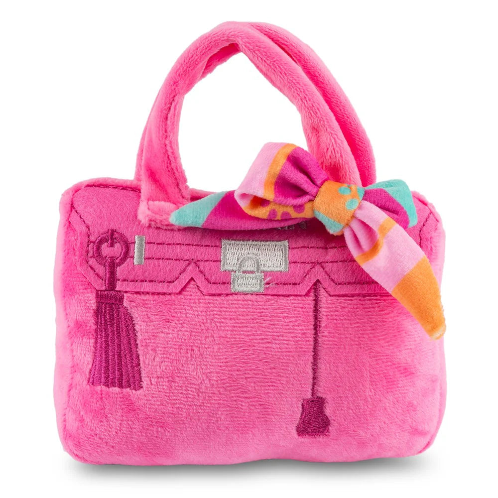 The Haute Diggity Dog Pink Barkin Bag Dog Toy is a chic plush purse with bright pink color, embroidered details, and a striped bow—a stylish accessory-inspired dog toy.
