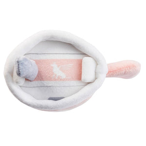 The Snuggly Cup Dog Toy, Blush by Haute Diggity Dog is a soft, plush dog toy shaped like a frying pan with a handle, featuring a pink and white color scheme and a small plush egg inside.