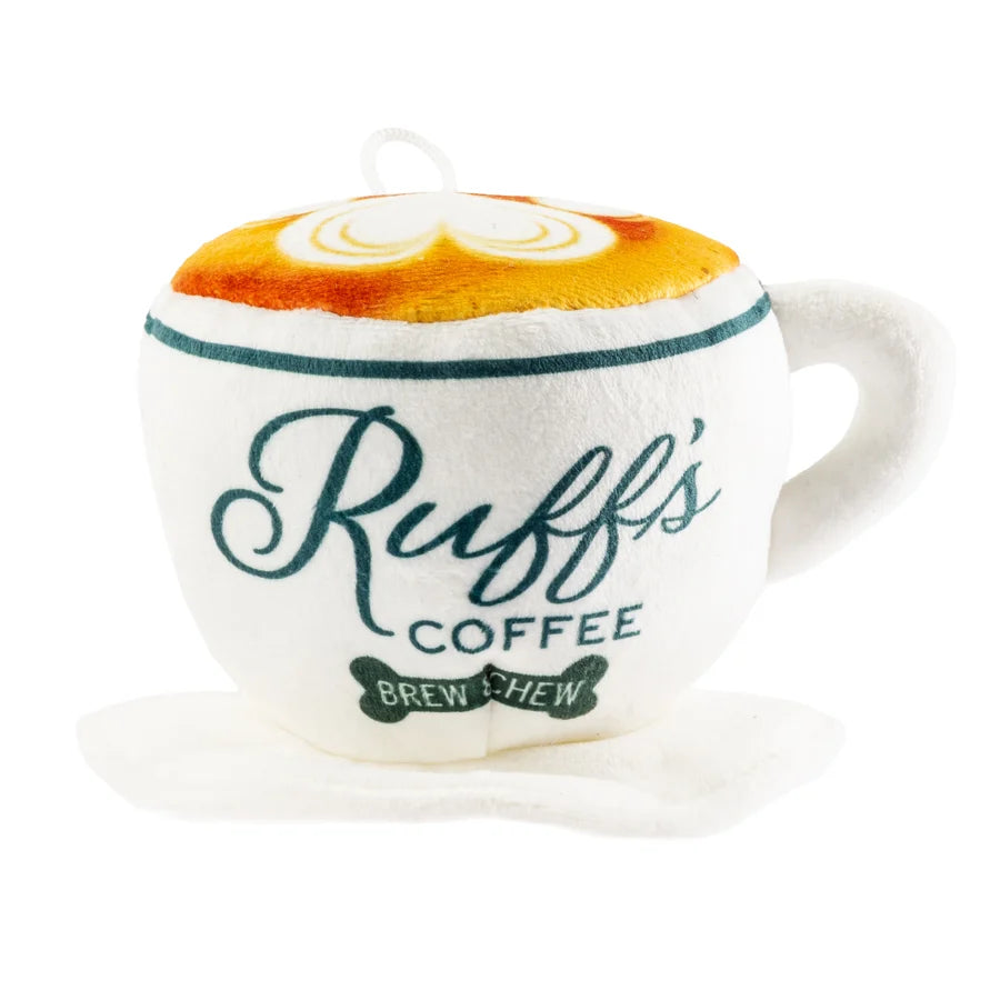 The Haute Diggity Dog Ruff’s Coffee Cup + Saucer Dog Toy is a plush squeaky dog toy shaped like a coffee cup with “Ruff’s Coffee Brew Chew” printed on it, complete with a latte art design, side handle, and attached saucer—an adorable and interactive plaything perfect for playful pups.