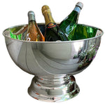 The Hôtel Silver Round Pedestal Chiller, a large silver-plate beverage cooler, elegantly displays and chills up to four bottles—wine, champagne, or sparkling water—on a gleaming reflective surface.
