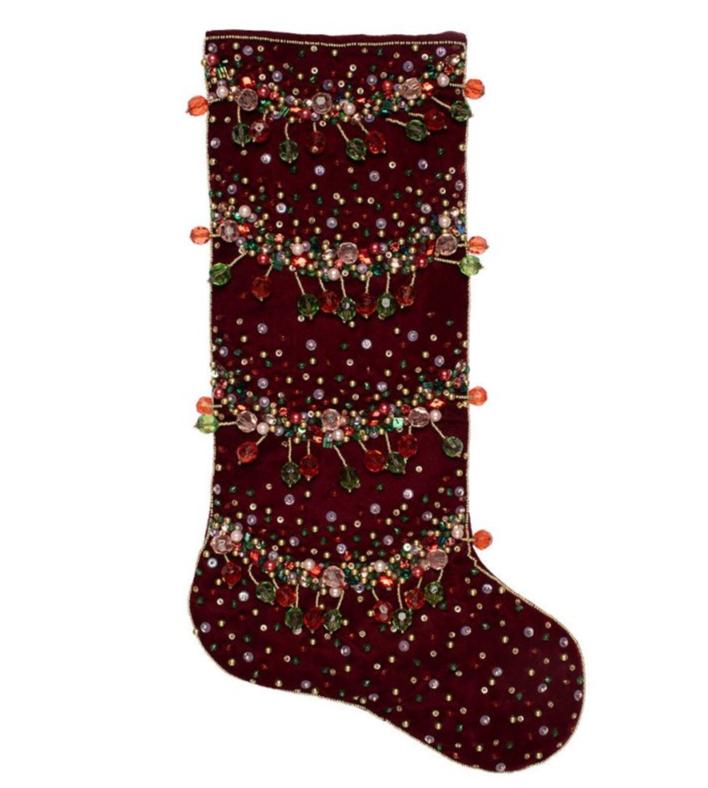 The Kim Seybert Celestial Stocking is crafted in burgundy velvet and embellished with rows of beads, sequins, and leaf-shaped ornaments for a festive touch.