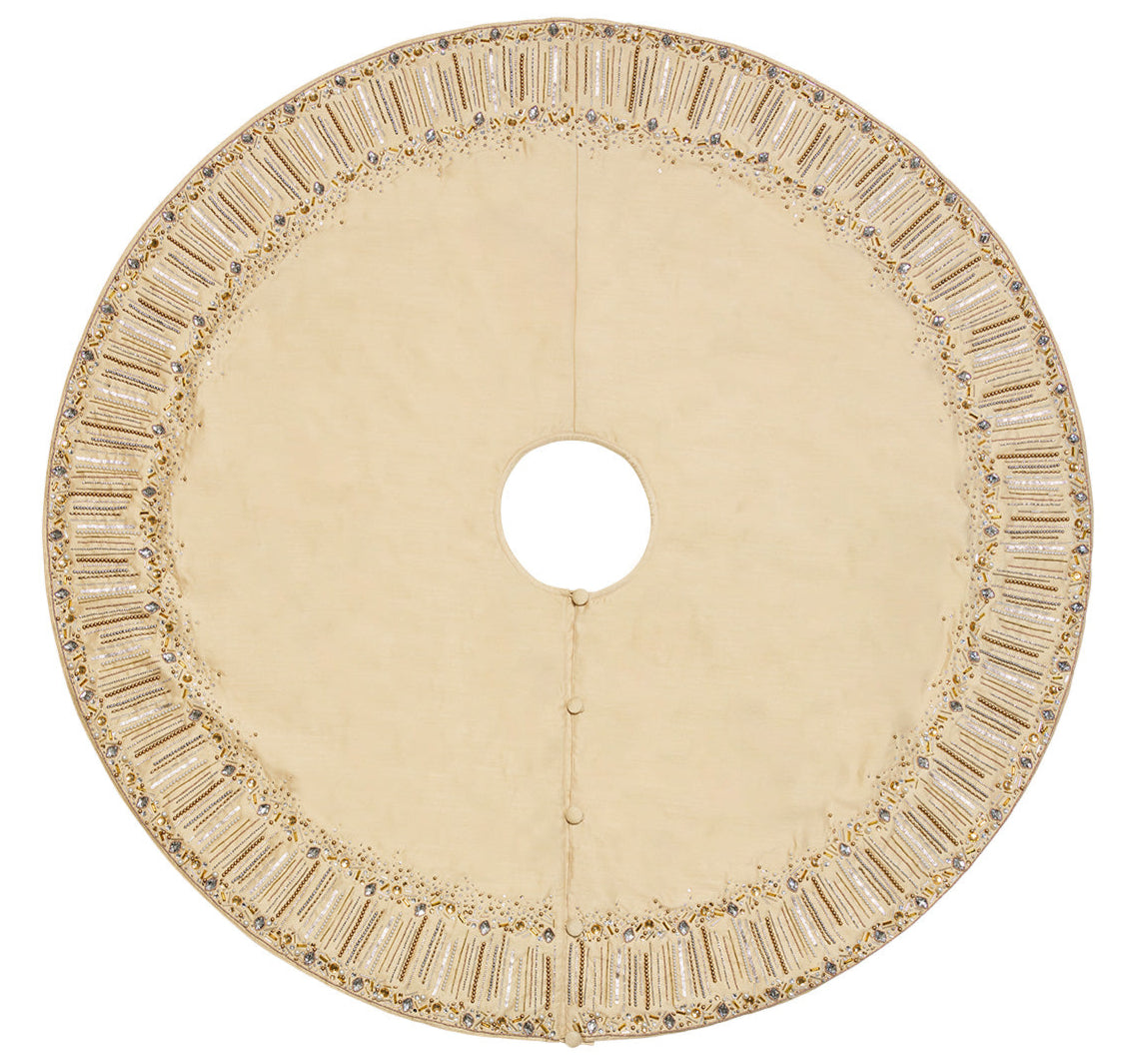 The Kim Seybert Gilded Sparkle Stocking and Tree Skirt Collection features a circular, cream champagne tree skirt with beadwork, three buttons, and luxe details—perfect for metallic holiday décor.