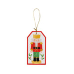 The Caspari Painted Nutcracker Hanging Tag features a cartoon nutcracker illustration and gold string—ideal for enhancing party supplies or adding charm to elegant table settings.