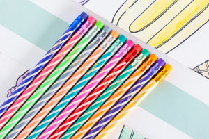 A row of vibrant, diagonally striped Hester & Cook Colored Pencils, each topped with a metallic ferrule and eraser.