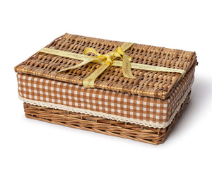 The Chic Gift Hamper by Sharland England features a rectangular wicker basket with brown and white gingham trim, lid, and yellow ribbon—ideal for presenting artisanal gifts like hand-poured candles or sustainable soap.