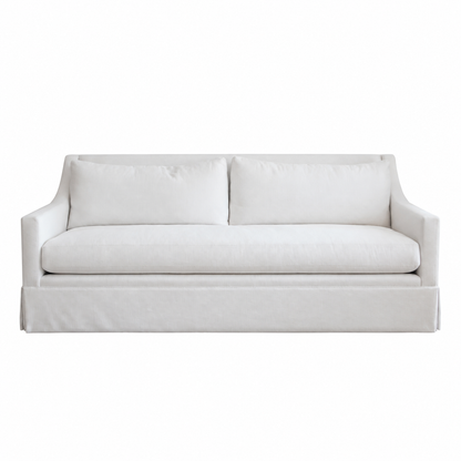 The Hannah Condo Sofa in Nit Witty Sea Salt by Verellen is a three-seat white sofa featuring straight arms, a tailored skirt, and two back cushions in a Sea Salt finish, shown against a plain white background. This compact design combines style and comfort, making it ideal for modern living spaces.