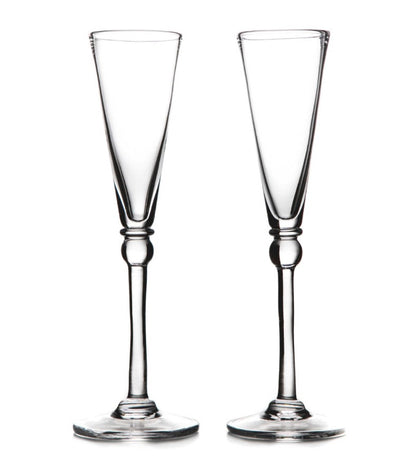 Two clear Hartland Champagne Flute glasses by Simon Pearce stand side by side on a white background—a perfect handmade gift set for an elegant wedding.