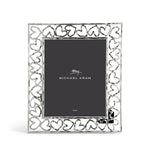 The Michael Aram Heart Frame Collection features a silver border of interlocking hearts that celebrate love, and displays a card with the brand name "Michael Aram.