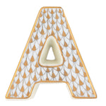 The Herend Letters collection features a ceramic letter "A" with a white base, gold border, and a repeating pattern of gold and grey teardrops, showcasing artistic detail often found in hand painted designs.