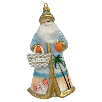 Add a festive touch to your tree with the Hive Santa Custom Ornament by Joy To The World Collectibles, Inc., featuring Santa in a blue and gold robe with beach motifs, holding an orange and a "HIVE" bag. Perfect for handmade ornament fans!.