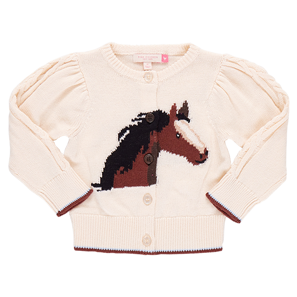 A cream-colored Pink Chicken Girls' Constance Sweater by Pink Chicken featuring a horse head design on the front, glitter button front closures, navy heart detailing, and slightly puffed sleeves.