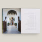 An open book, House Love: Moor Baker Architects by Vendome, displays a photo of a classical arched entryway on the left and a table of contents with chapter titles and page numbers on the right.