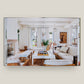 An open book, "House Love: Moor Baker Architects" by Vendome, displays a photo of a bright, modern living room with white walls, large windows, and contemporary furniture inspired by Florida architects.