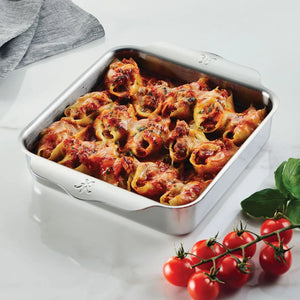 The Hestan Provisions OvenBond Square Baking Pan is filled with baked stuffed pasta shells topped with cheese and tomato sauce, garnished with basil and cherry tomatoes—ideal for holiday entertaining.