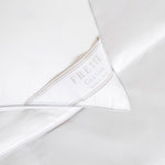Close-up of a white Frette Cortina Firm Density Pillow Insert, featuring a label that reads "Frette Cortina Made in Italy.