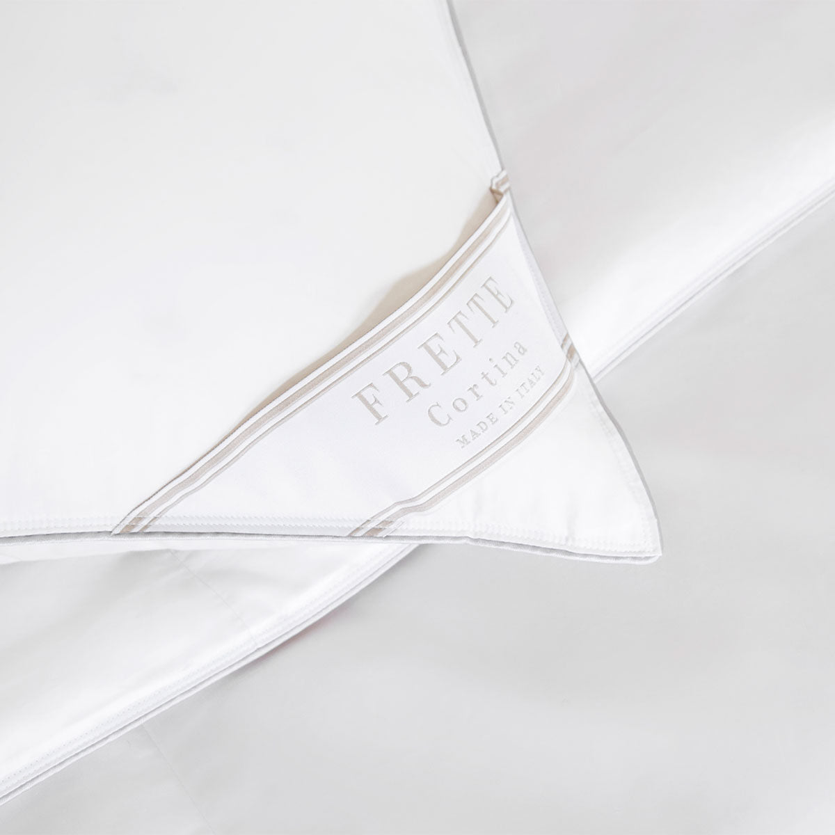 Close-up of a white Frette Cortina Firm Density Pillow Insert, featuring a label that reads "Frette Cortina Made in Italy.
