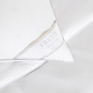 Close-up of a white Frette Cortina Firm Density Pillow Insert, featuring a label that reads "Frette Cortina Made in Italy.