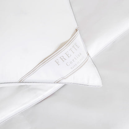 Close-up of a white Frette Cortina Firm Density Pillow Insert, featuring a label that reads "Frette Cortina Made in Italy.
