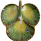 The Anna Weatherley Leaf Tray is a Hungarian porcelain dish shaped like three green and yellow leaves, adorned with hand-painted insects and gold trim.