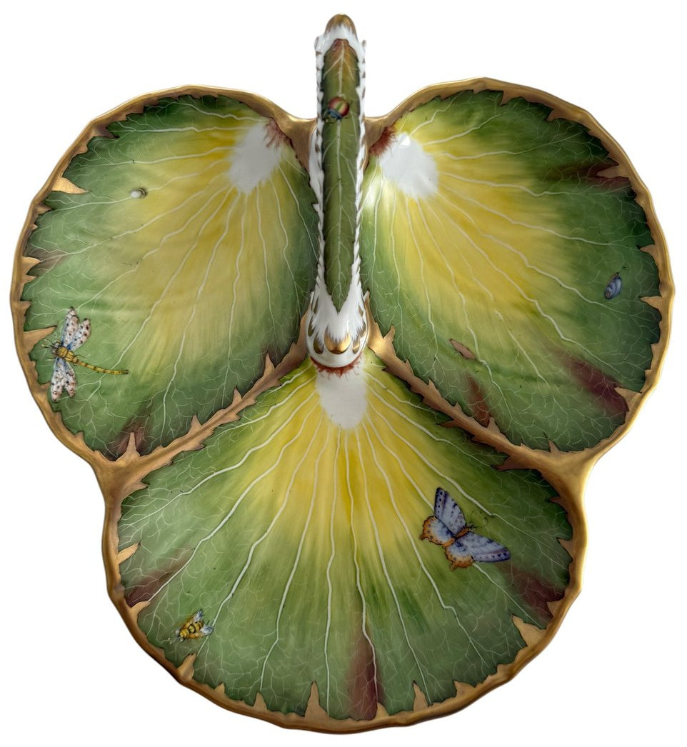 The Anna Weatherley Leaf Tray is a Hungarian porcelain dish shaped like three green and yellow leaves, adorned with hand-painted insects and gold trim.