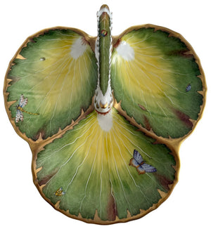 The Anna Weatherley Leaf Tray is a Hungarian porcelain dish shaped like three green and yellow leaves, adorned with hand-painted insects and gold trim.