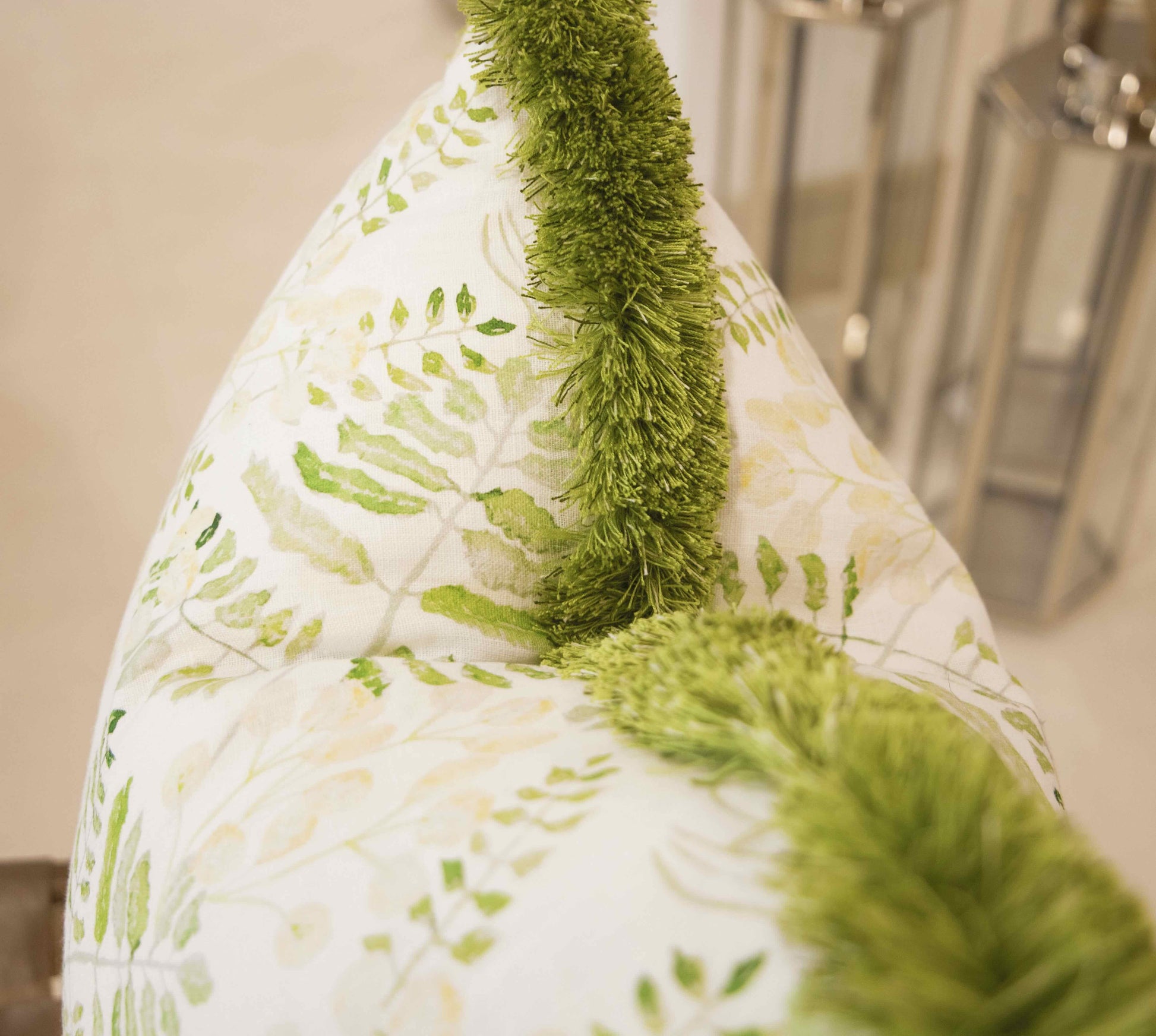 A close-up of the Fern Yellow Pillow by Hive Custom Pillows, featuring a green leafy design and soft fuzzy trim—an ideal choice for anyone seeking a unique, down-filled accent for their space.