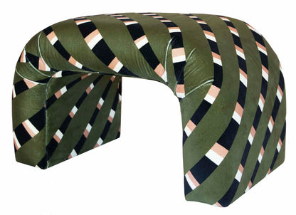 A Martini Small Ottoman by Associated Design with a curved structure featuring diagonal patterns in black, white, and pinkish-tan stripes, reminiscent of the bold designs showcased at the Kips Bay Show House.