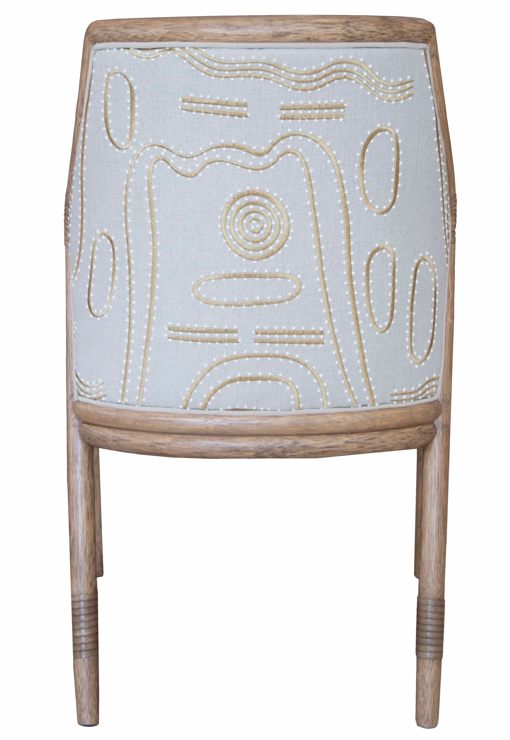 The McGuire Lantana Side Chair, Mushroom features a wooden frame with beige fabric on the backrest, adorned with an embroidered abstract pattern in white and yellow. The furniture dimensions are 21.25"W and 23"D, offering a comfortable yet stylish seating option.