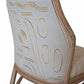 Close-up view of a McGuire Lantana Side Chair, Mushroom with intricate embroidery on the backrest, featuring abstract patterns in cream and beige tones, set within a light wooden frame. The furniture dimensions are 21.25"W and 23"D.