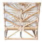 The Sea Cliff Slipper Chair, Palmetto Stripe by Selamat is a wicker slipper chair with a geometric back design, accented with light-colored bamboo and rattan – perfect for evoking the feeling of a Sea Cliff retreat. It includes a white cushion that features an elegant radial pattern adorned with tan lines.
