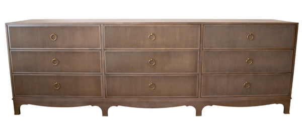 The Reeded Dresser by Century Furniture is a low dresser with a light brown finish featuring nine drawers, each adorned with circular gold pull handles and a reeded case front.