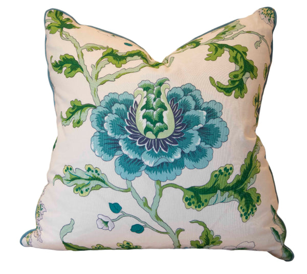 The New Athos Spring Pillow by Associated Design is a square pillow with large blue flowers and green leaves on a white background, crafted from premium materials to offer comfort and elegance in any space.