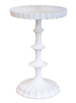 The Priscilla Side Table by Oly features a white, sculpted fluted base and a wavy scalloped tabletop edge, offering understated luxury as a sophisticated focal point for any room.