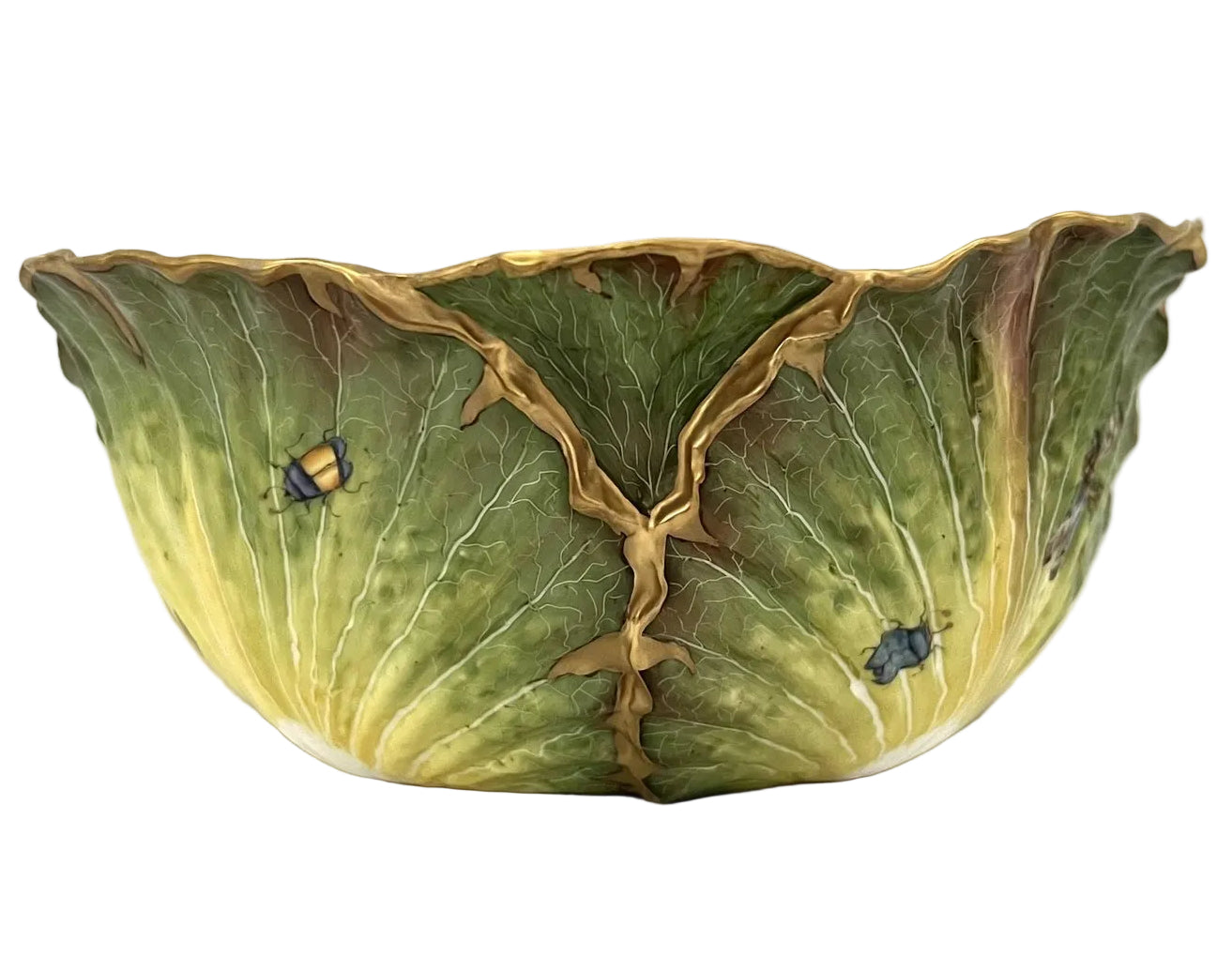 The Anna Weatherley Cabbage Bowl is a hand-painted Hungarian porcelain piece shaped like green cabbage leaves with gold edges and small painted insects.