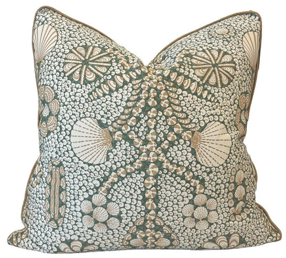 The Shell Grotto Green/Tan Pillow by Associated Design features a custom square shape with a green and beige floral and shell pattern on white, crafted from premium materials and displayed against a plain background.