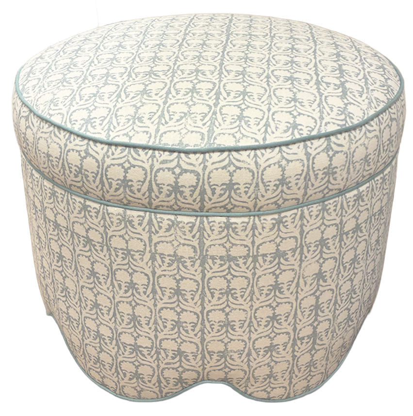 The Suzie Scalloped Ottoman by Highland House showcases blue and beige patterned upholstery and scalloped edges, making it a chic and versatile piece for extra seating or use as a footrest in any room.