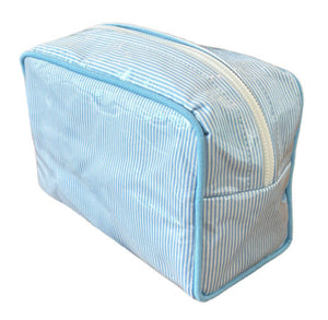 The Walker Valentine Milan Cosmetic Case features a rectangular shape with blue and white stripes, a zipper closure, and blue piping along the edges.