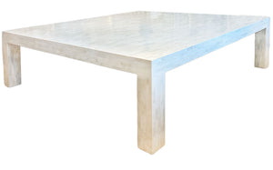The Bojay Bone Inlay Cocktail Table features a large, rectangular shape, thick legs, and a white finish—perfect for adding elegant bone inlay artistry to any stylish living room.