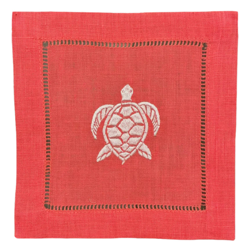 The Coastal Cocktail Napkin Set by Pink House Mustique features square red linen napkins with a white embroidered turtle design and decorative coastal-inspired stitching.