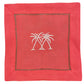 The Coastal Cocktail Napkin Set by Pink House Mustique features red linen napkins with two white palm trees embroidered at the center and a decorative stitched border, perfect for adding a coastal touch to any gathering.