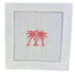 The Coastal Cocktail Napkin Set by Pink House Mustique features white linen napkins with embroidered pink palm trees at the center and a coastal-inspired hemstitch border.