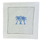 The Coastal Cocktail Napkin Set by Pink House Mustique features white linen napkins with two blue embroidered palm trees at the center and a decorative hemstitch border.