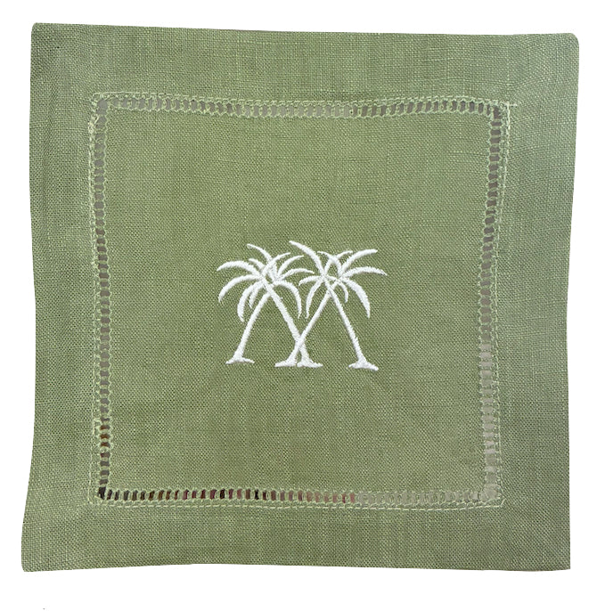 The Pink House Mustique Coastal Cocktail Napkin Set features coastal green linen napkins with two white embroidered palm trees in the center and a decorative stitched border.