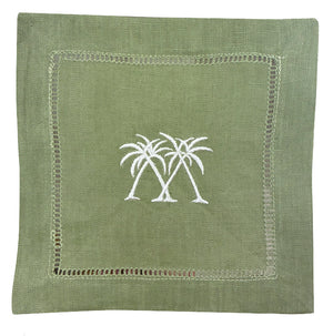 The Pink House Mustique Coastal Cocktail Napkin Set features coastal green linen napkins with two white embroidered palm trees in the center and a decorative stitched border.