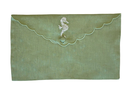 From the Pink House Mustique Linen Envelope Pouch Collection, this green pouch features a scalloped flap, button closure, and delicate white floral embroidery near the top center for a touch of coastal charm.