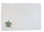 The Pink House Mustique Coastal Linen Placemat Set features plain white placemats with a small green sea turtle design in the bottom left corner—ideal for bringing a beach-inspired touch to your dining table.