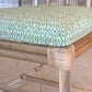 Close-up of the Sea Cliff Side Chair, Amala Vert by Associated Design, with an acrylic and bamboo frame and a custom green Amala Ikat cushion, set on a tiled floor.